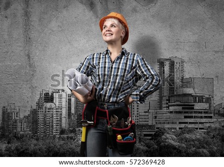 Engineer woman with blueprints and sketches of construction project on wall