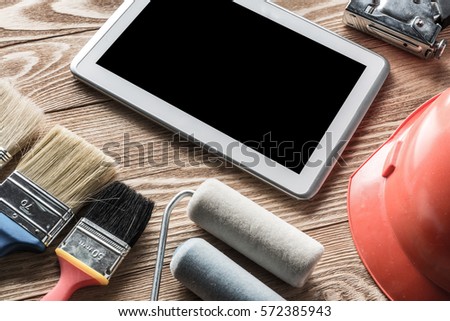 Variety of tools of builder and tablet pc on wooden texture table