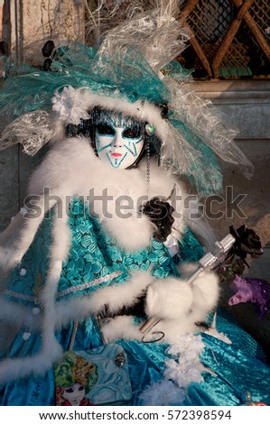 Beautiful mask in white and azure costume at the Venice Carnival
