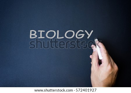 Hand writing text biology on the chalkboard.