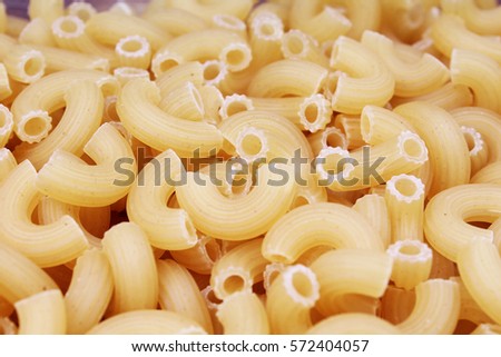 Macaroni raw dry pasta background concept. Pasta texture for background uses. Swirled pasta pattern. Food photography in studio.