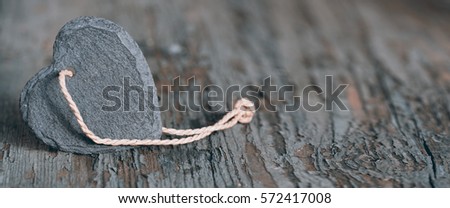 A heart made of slate for love greetings on an old shabby wooden table for valentines day and mothers day