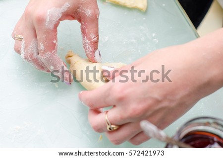 Girl makes homemade cinnamon buns, sliced rolls of dough roll. View from above, hands in picture