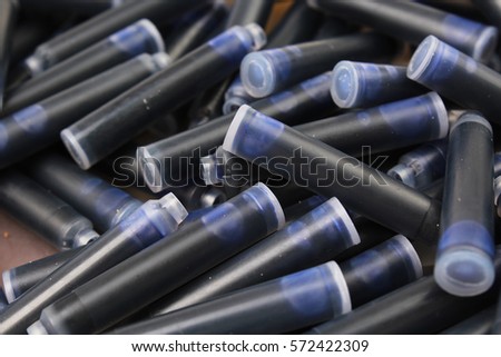 Pen ink Cartridge. Close up of the nib of a fountain pen ink cartridges. Inks as background. Texture photo studio photography