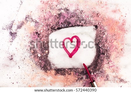 Lip gloss on white marble background, with traces of powder and blush forming a frame with a heart in it. 'Love Makeup' valentine card design