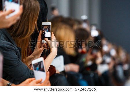 Woman holding phone during the fashion show