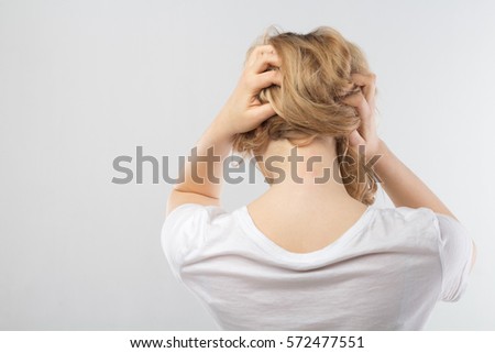 Back view of woman with skates on shoulders touching her head. Vertical outdoors shot