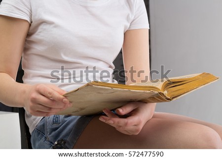 Close-up of female hands holding open book. Reading concept background