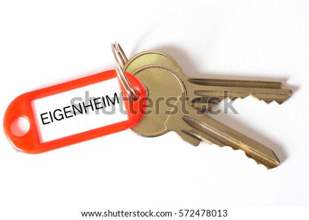 A key and a key chain with the German word for home ownership