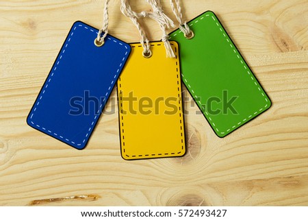 Multicolored blank label price tag on a background of light wood. Country style.