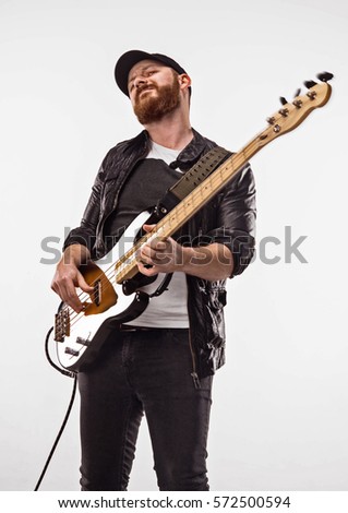 Bassist plays bass guitar. Neutral background