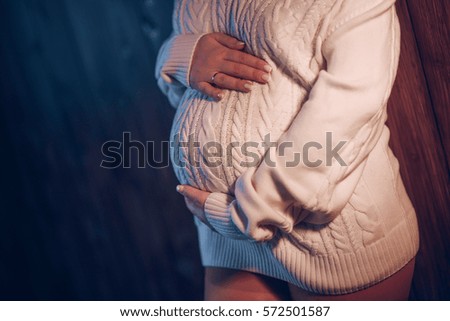 The woman hugs your pregnant belly. Romance