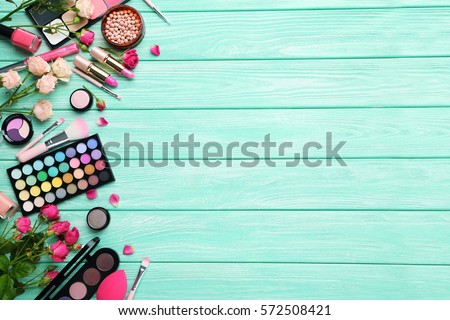 Different makeup cosmetics on mint wooden table Royalty-Free Stock Photo #572508421