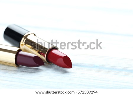 Colorful lipsticks on blue wooden table
