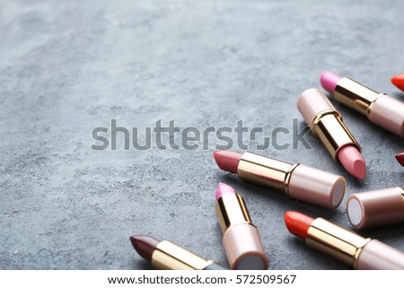 Colorful lipsticks on grey wooden table