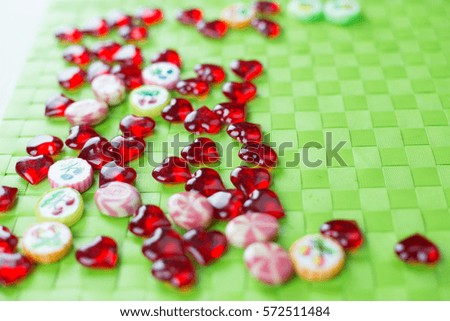 Red heart candy lollipops green background