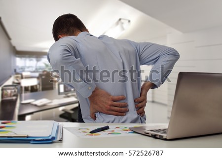 Business man with back pain an office . Pain relief concept Royalty-Free Stock Photo #572526787