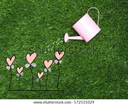  hand  watering love heart  trees  on color background and top wood table for Christmas and The New Year and Valentine's day .Decoration love heart and drawing free hand cartoon cute love.
