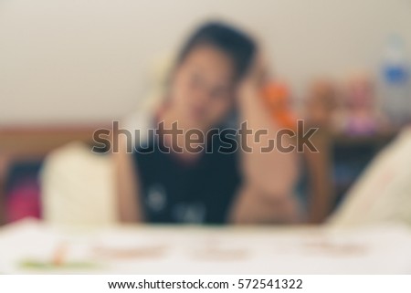 blurred image of asian woman serious about the work done until the headache