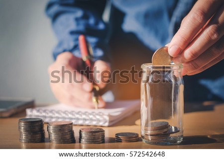 Saving money concept Man hand putting Row and coin Write Finance Royalty-Free Stock Photo #572542648