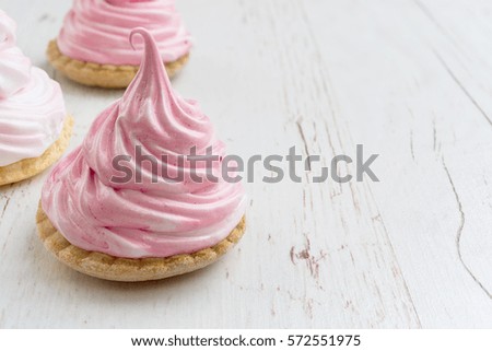 Freshness pink meringue on the white wooden background, closeup