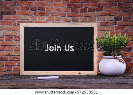 Join Us word on blackboard with green plant