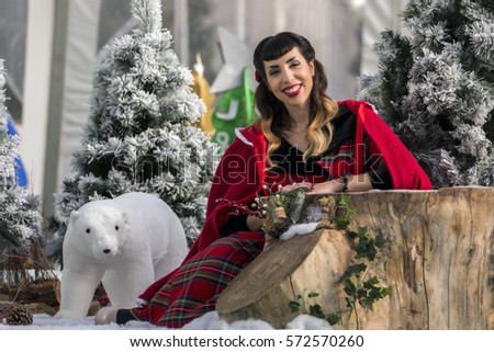View of a colorful and cute christmas pinup girl in a winter scene.