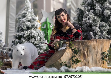 View of a colorful and cute christmas pinup girl in a winter scene.