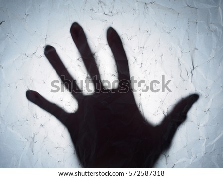 Hand shadow behind paper