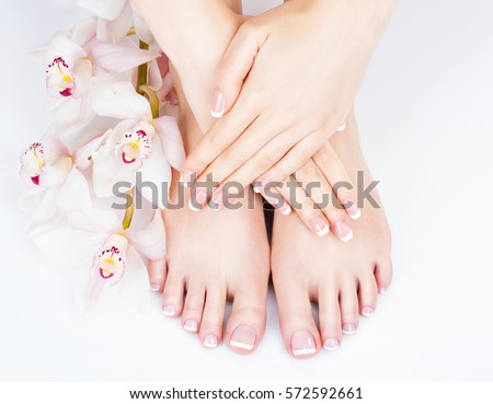 Closeup photo of a female feet at spa salon on pedicure and manicure procedure - Soft focus image Royalty-Free Stock Photo #572592661