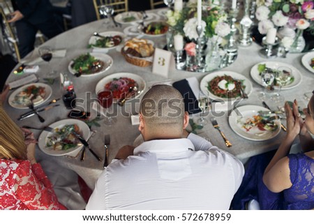 Guests sit at the rich wedding dinner tables