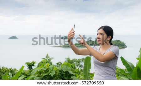asian woman selfie with seascape against blue sky