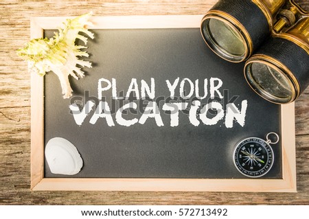Retro holiday concept with flare effect (plan your vacation). Vintage binocular, compass, sea shells and blackboard on a wooden table.