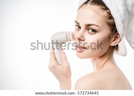Young Happy woman with funny face uses an electric brush for deeply clean on the nose, laughing and enjoy expression.Isolated on white