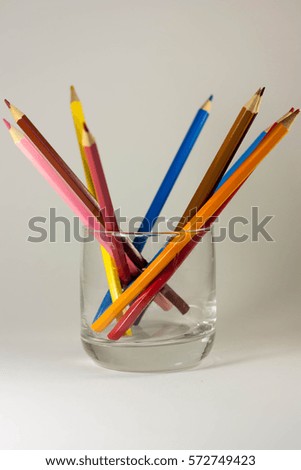 Colored pencils in a glass on a white background, isolated