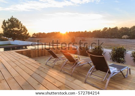 Chairs in modern house with wooden deck