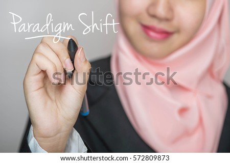 Business woman writing text : Paradigm Shift over gray background