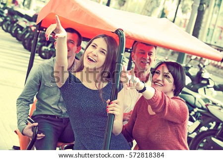Happy couple with adult children sitting in grand tour electric of Europenian city