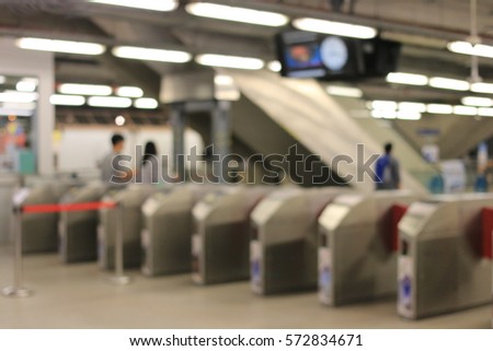 Blurred image of People a the Gate or Ticket barrier at railway of Airport Rail Link train station in Bangkok, night time, Thailand.
