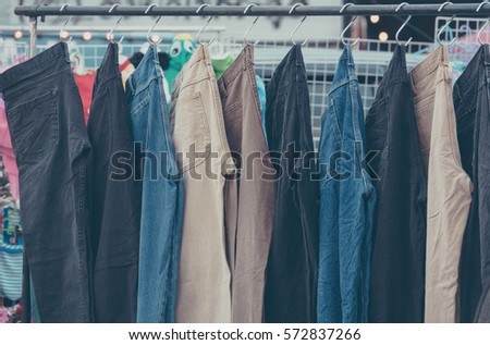 A rack of a variety of blue denim jeans in various shades of blue in market
