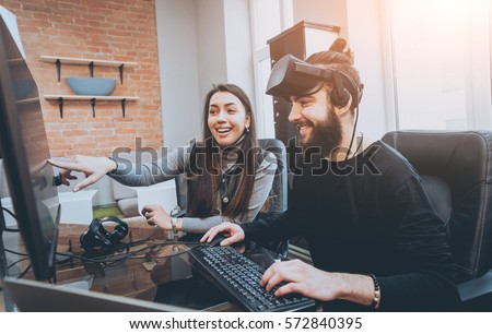 The young man with girlfriend plays a game at the office. Virtual reality Royalty-Free Stock Photo #572840395