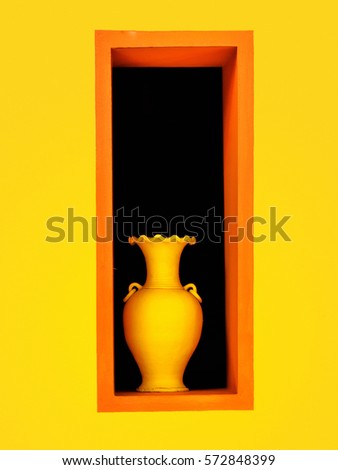 Yellow wall and yellow terracotta vase in the orange window.