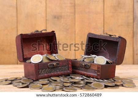 Treasure chest with countless money coin and have a wood floor in the background