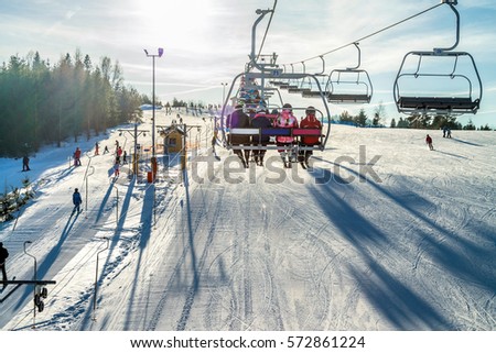 Chairlift for skiers - People on ski lift Royalty-Free Stock Photo #572861224