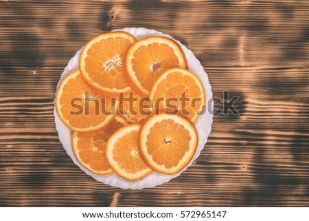 dish of sliced oranges on burnt wooden desk with. food pattern - vintage film effect