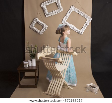 little girl in a blue dress on a brown background
