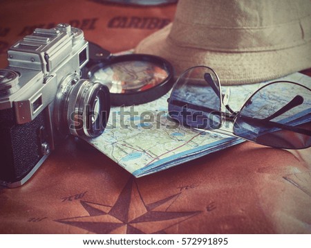 Concept of travel traveler travelling. sunglass camera map and hat on brown leather background.Copy Space vintage tone. Toned Image.