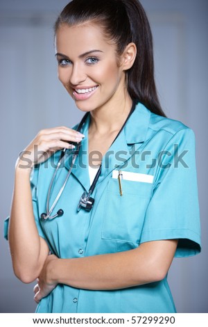 Portrait of beautiful female doctor on gray background