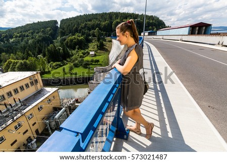 View of a girl at the concrete dam and hydroelectric plant station in Orava, Slovakia