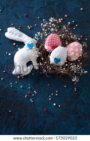 Easter eggs in the nest on rustic dark blue background
